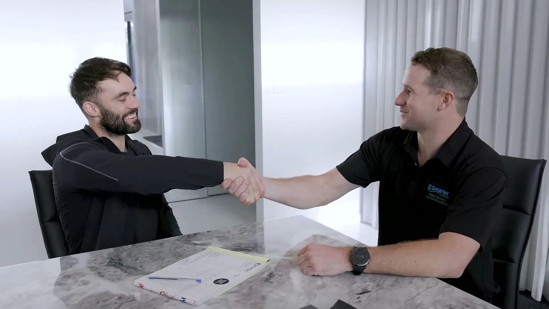 Smarter Outdoors consultant shaking hands with a customer over a signed quote
